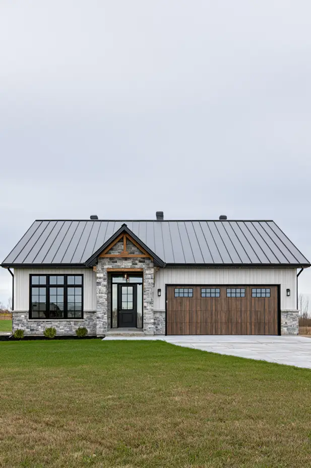 Single-story white ranch with a black standing-seam metal roof, stone entry, timber brackets, and a wood garage door