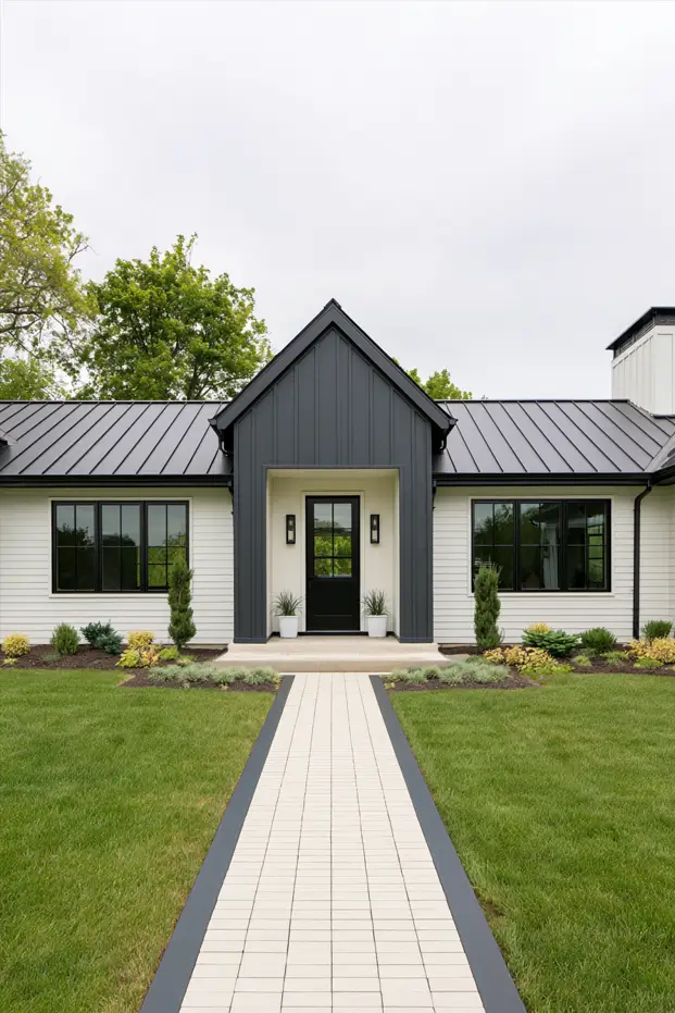 Single-story white ranch with a peaked charcoal board-and-batten entry portico, black door, metal roof, and paver walkway
